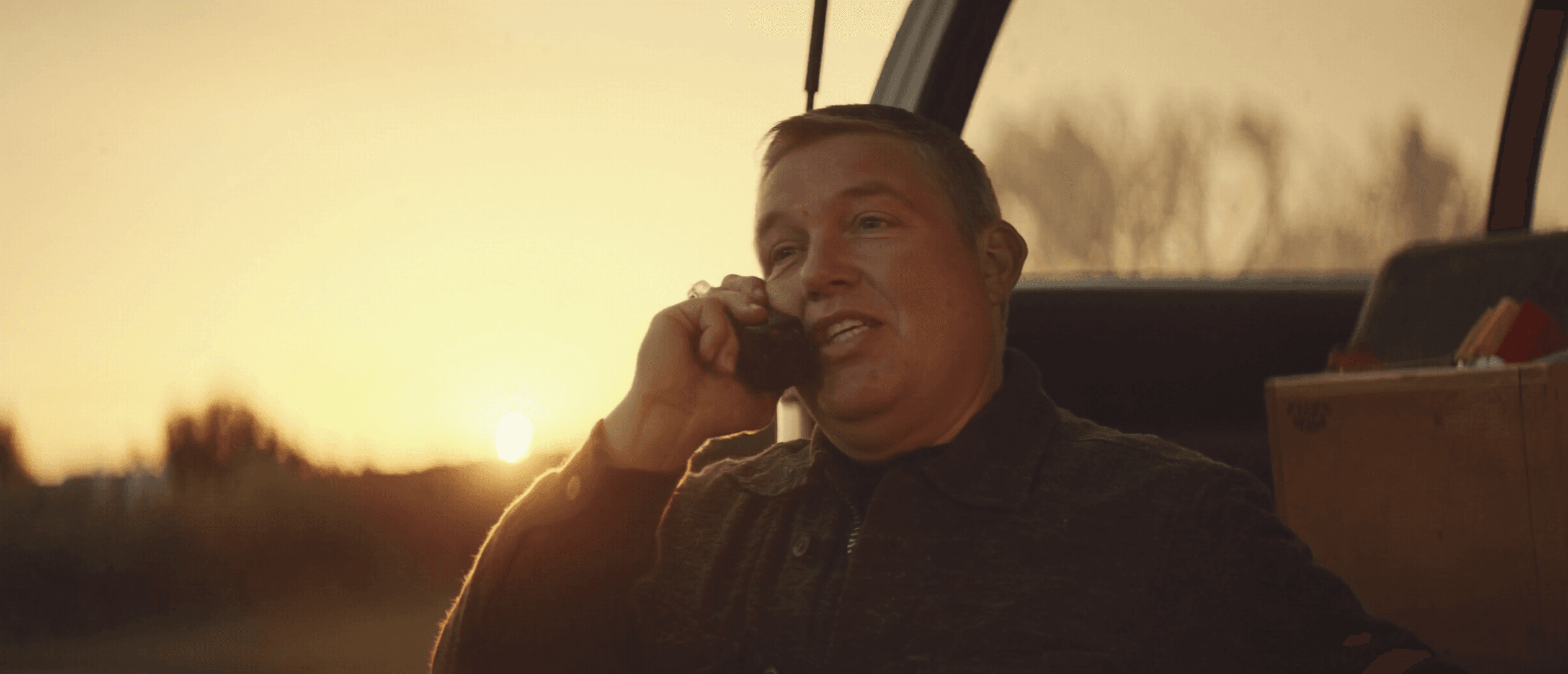 A business owner on the phone with a customer at golden hour