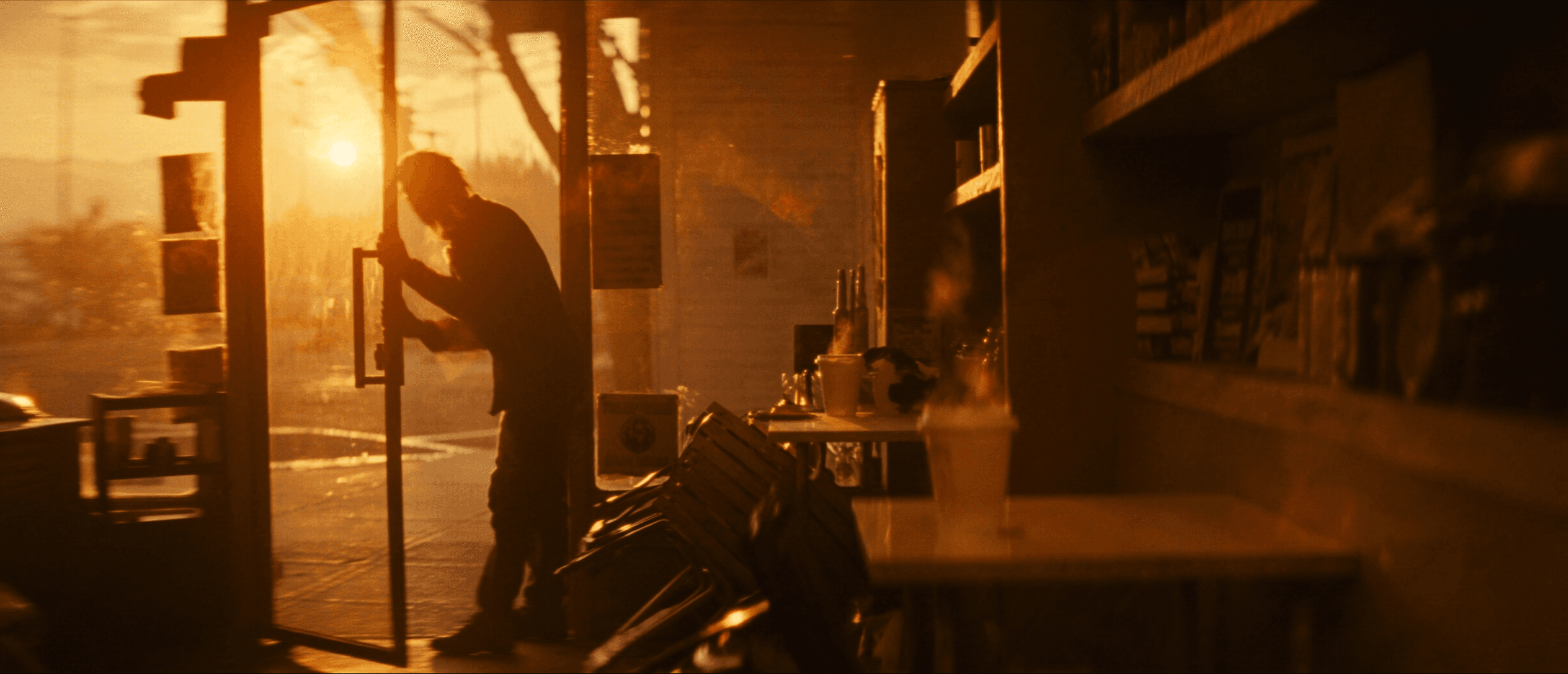 A shop owner propping the front door open at sunrise
