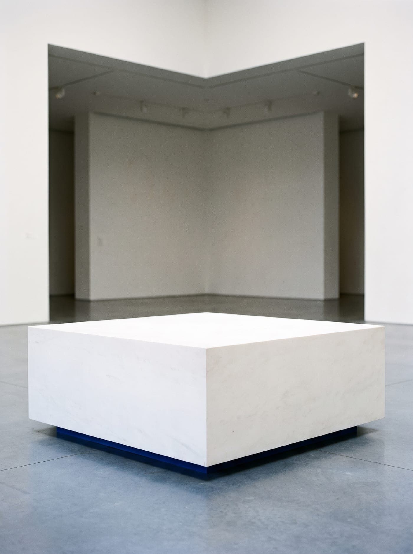 A single porcelain plinth in a bright gallery, the first stage of a build